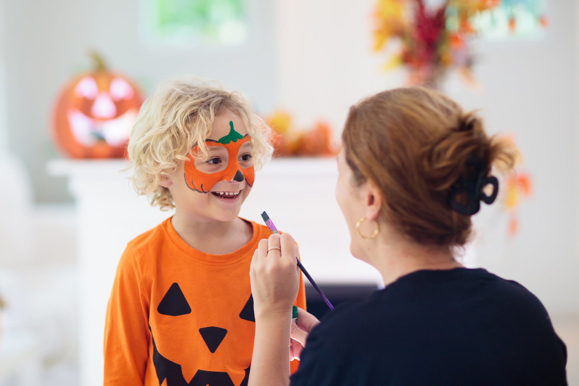 Jongen geschminkt als pompoen met Halloween