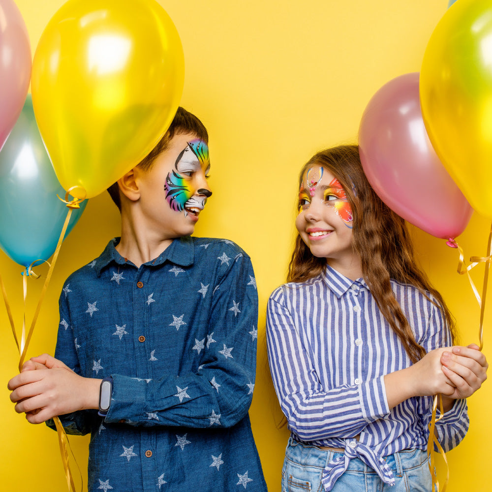 Kinderen met vrolijke carnaval schmink die ballonnen vasthouden tijdens een kleurrijk carnavalsfeest