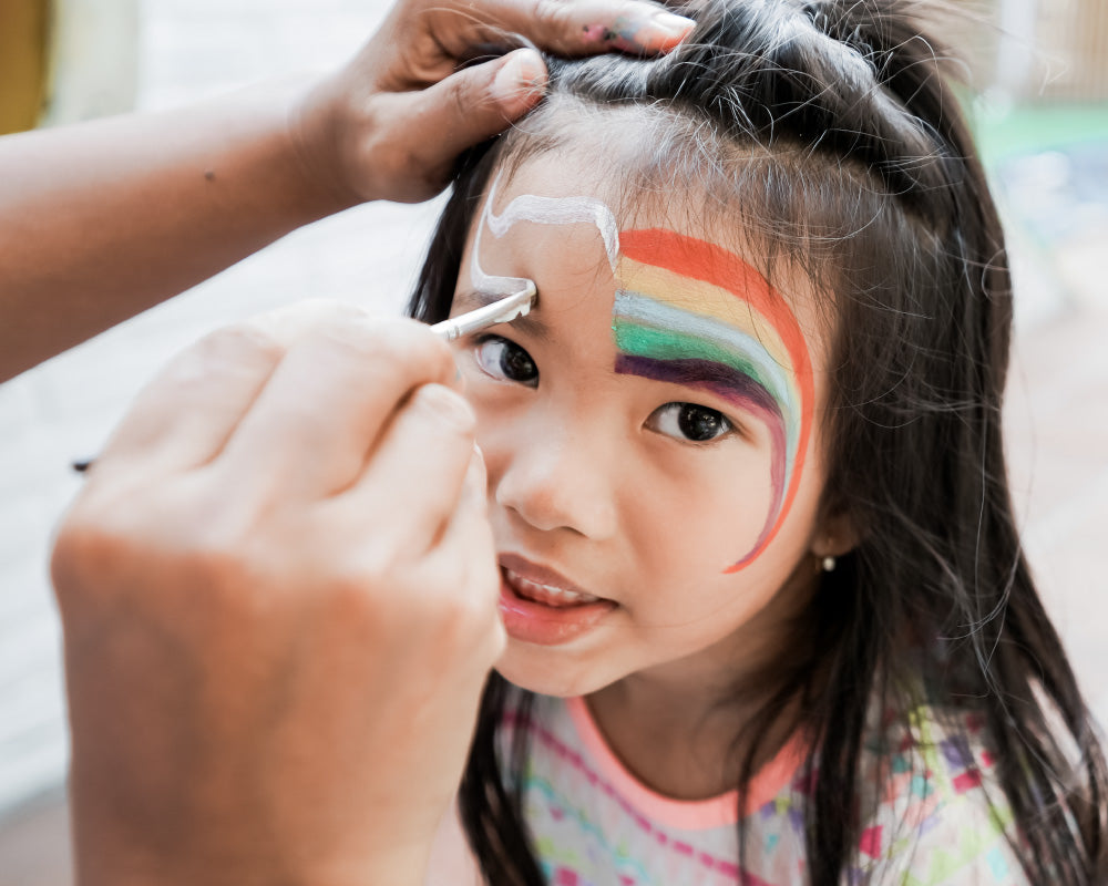 Kleurrijke schminkpenselen worden gebruikt voor een regenboog unicorn