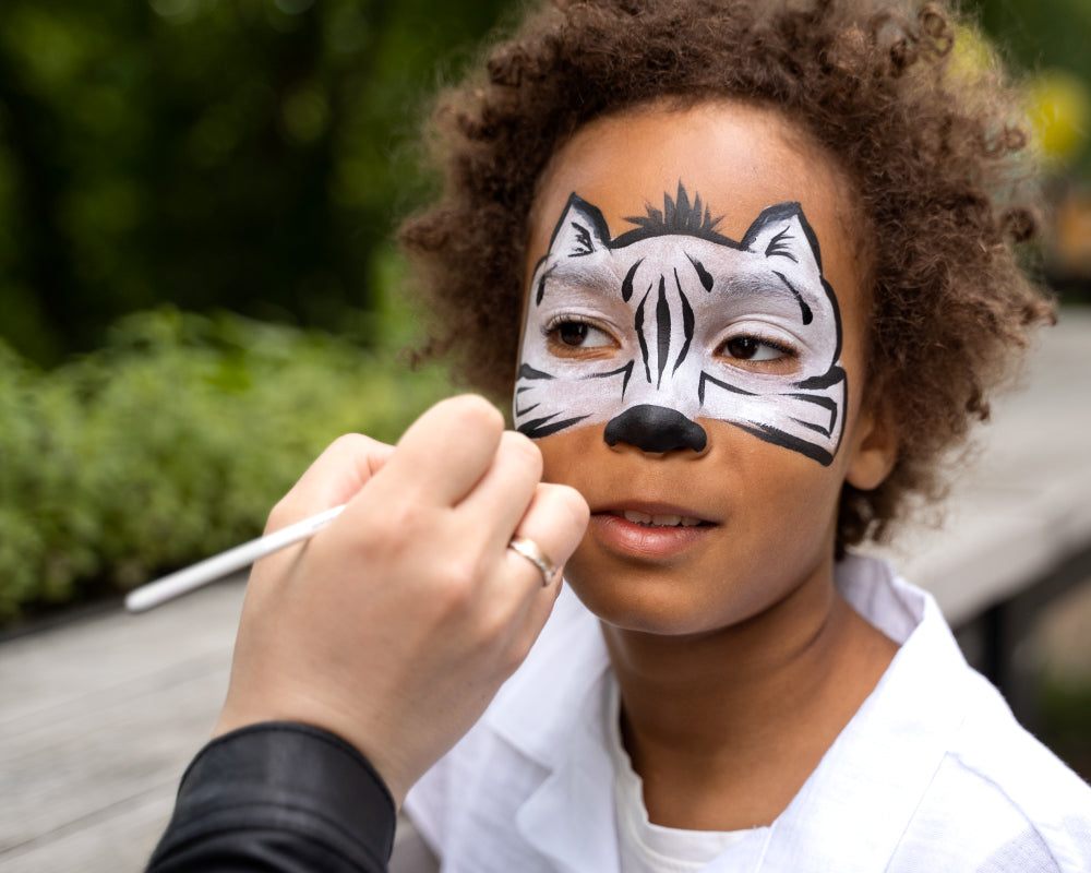 Kindergezicht beschilderd met zwarte en witte kleuren uit een schmink set