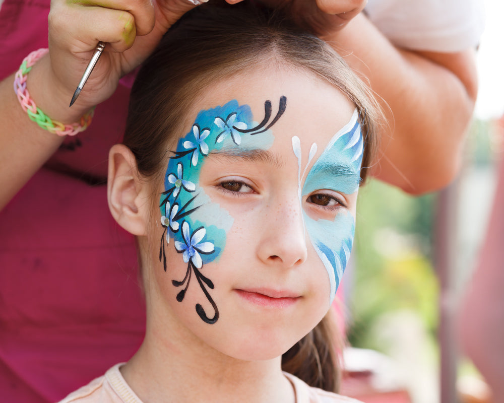 Kindergezicht beschilderd met pastelkleuren uit een schmink set