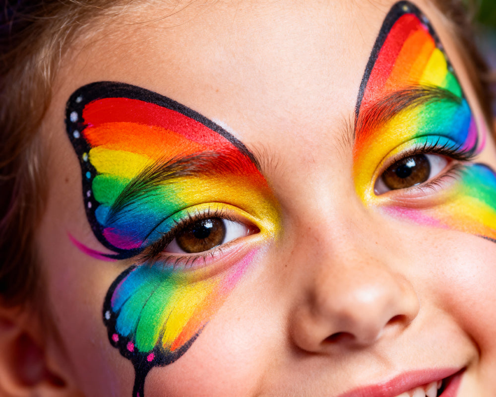 Regenboog gezichtsschmink gemaakt met splitcake schmink